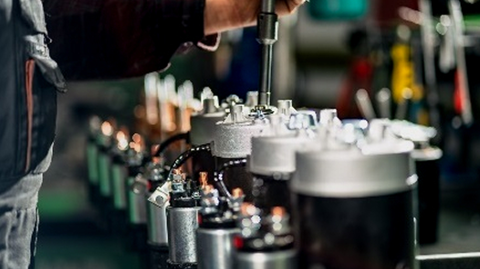 Close-up of turbocharger core inspection process with cores lined up in a row, showing technician's hand performing precise measurements using a measuring tool